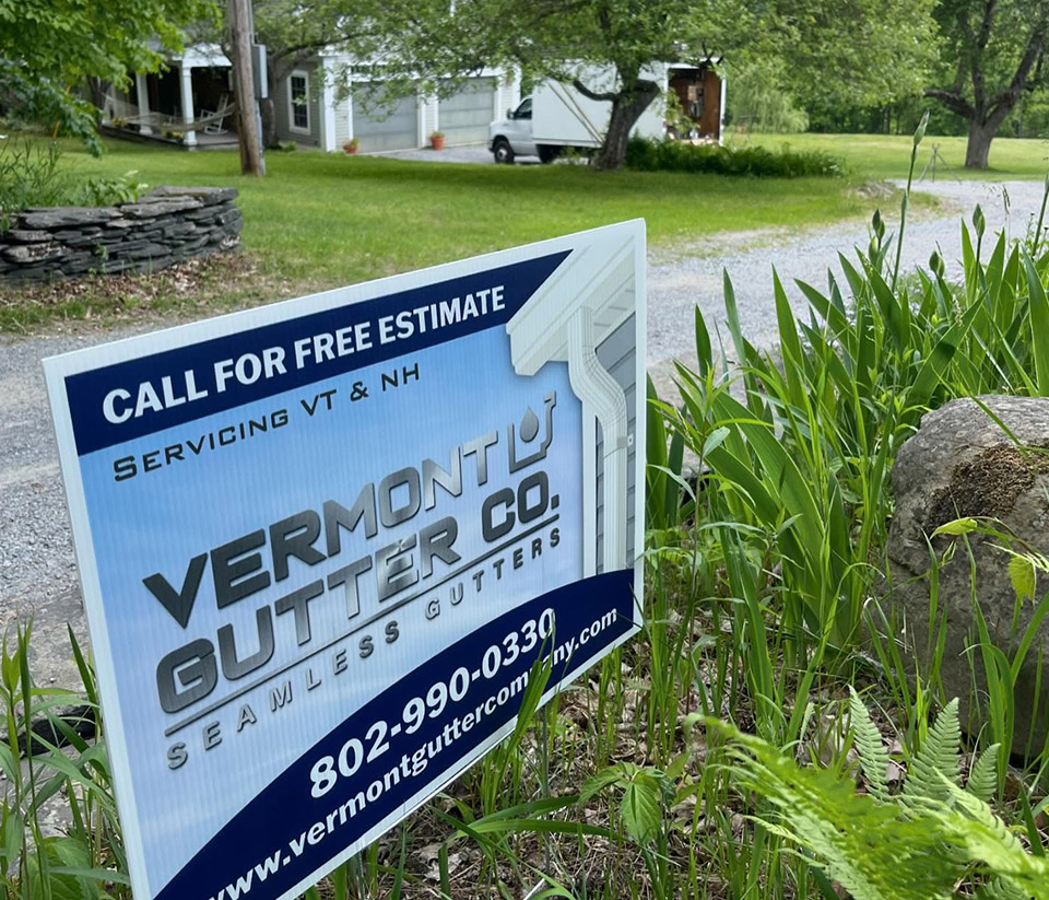 vermont-gutter-company-barre-vt-1 Close-up of the Vermont Gutter Company sign in the yard of a home in Barre, VT, surrounded by green grass.