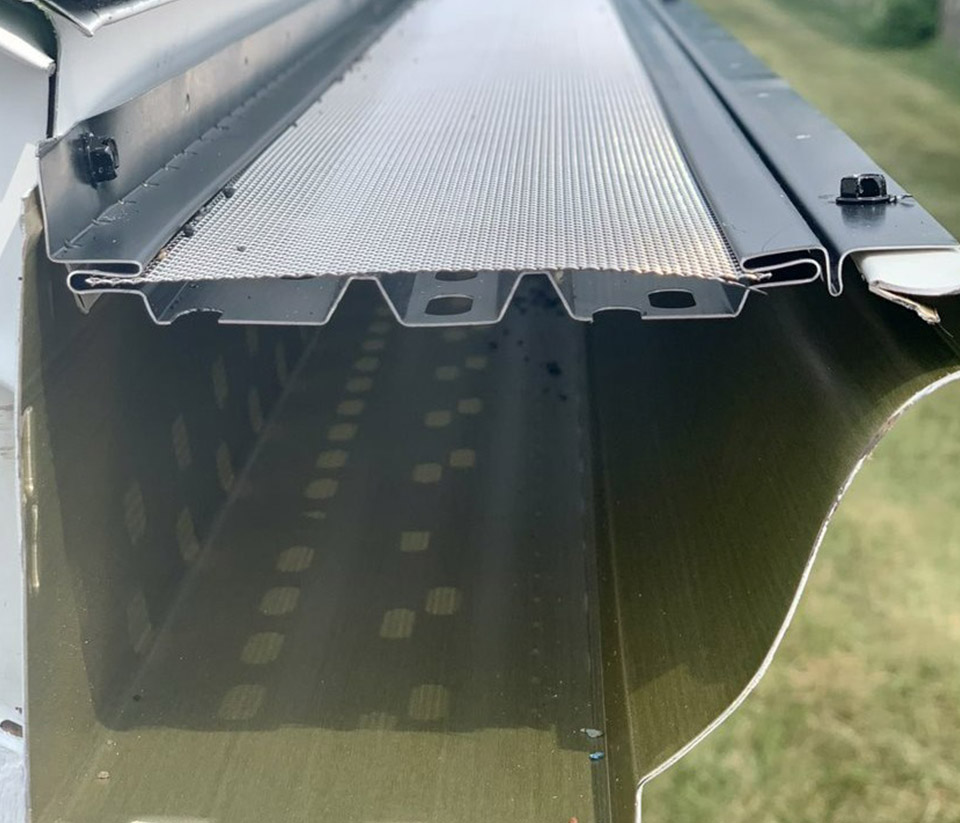 vermont-gutter-company-barre-vt-6 Side of a gutter with a gutter guard attached to a home in Barre, VT.