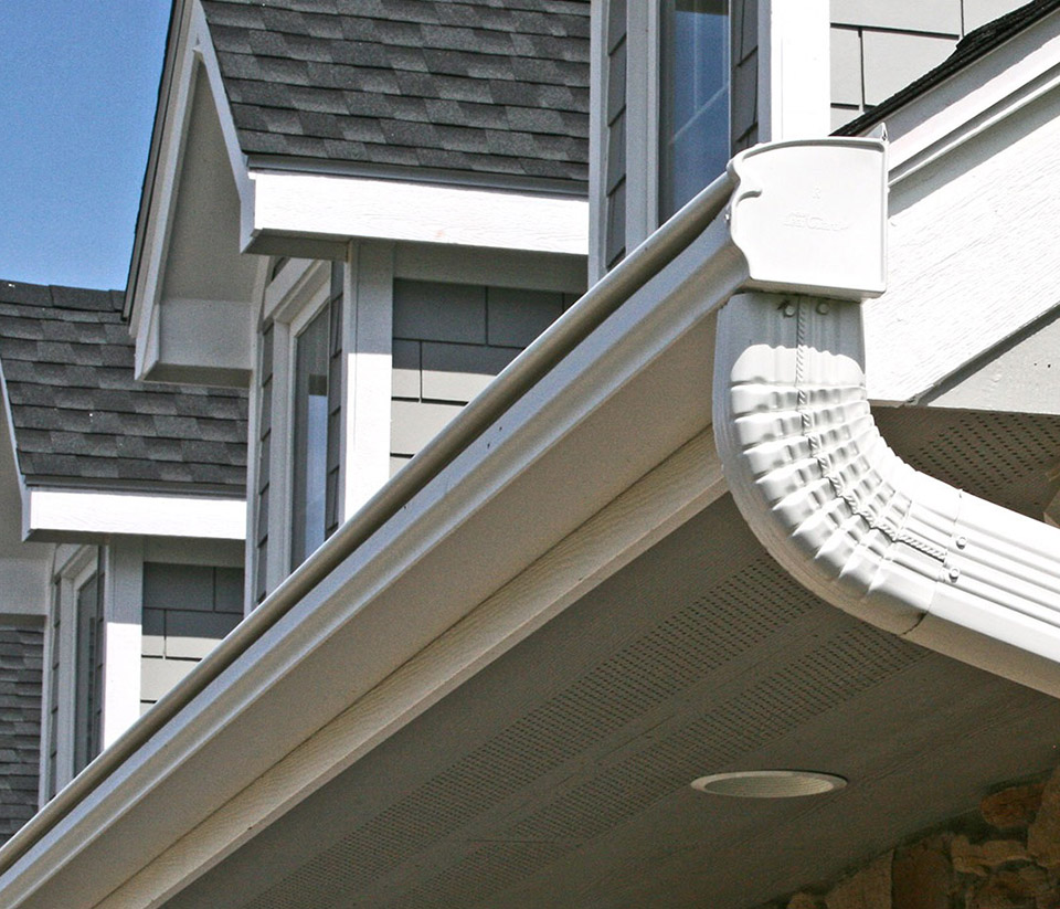 vermont-gutter-company-milton-vt-1 Close-up of the side of a home featuring white gutters in Milton, VT.
