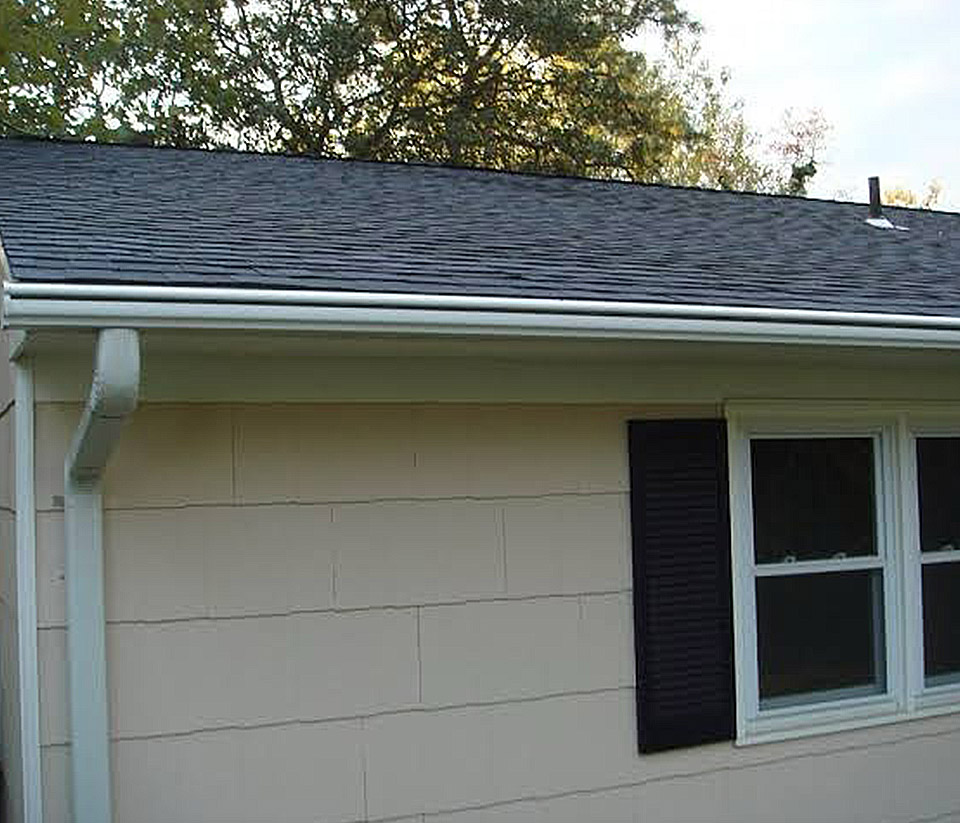 vermont-gutter-company-rutland-vt-4 Close-up of the side of a home in Rutland, VT, showing white gutters along the roofline.