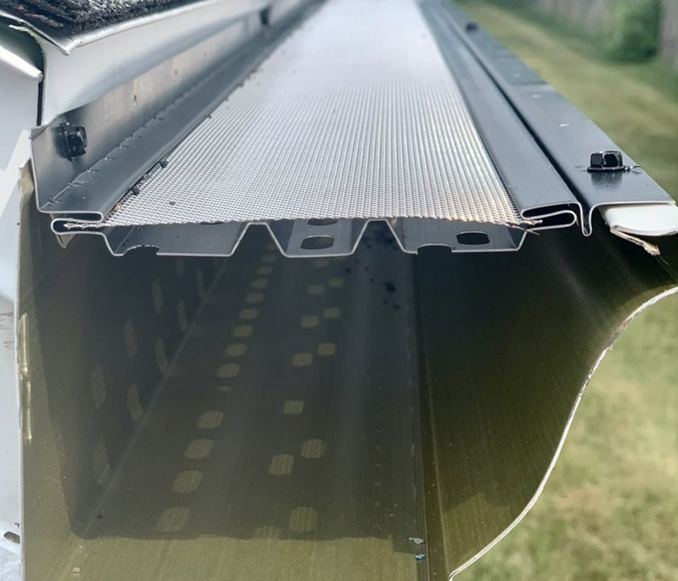 vermont-gutter-company-south-burlington-vt-6 Close-up of a gutter with a gutter guard on the side of a home in South Burlington, VT.